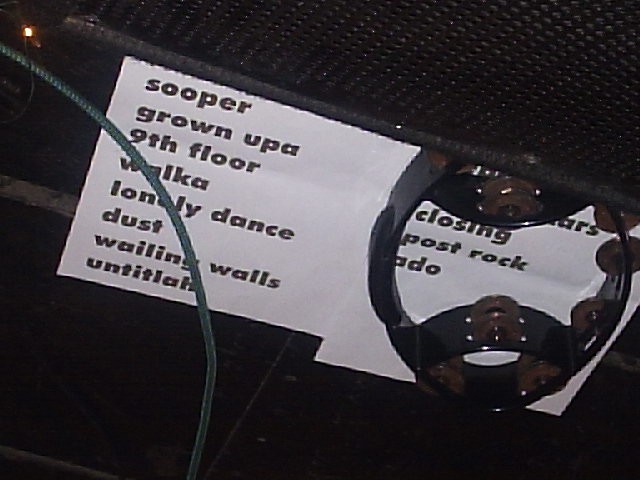 Sheet of paper listing songs next to an instrument.